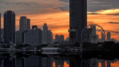 Modern buildings against sky during sunset