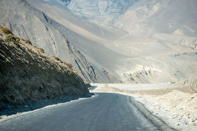 Scenic view of road by mountains against sky