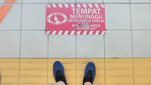 Low section of person standing on tiled floor