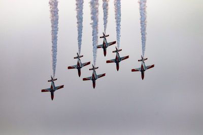 Low angle view of fighter planes flying against sky