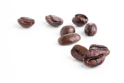 High angle view of coffee beans against white background