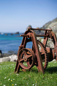 Close-up of rusty machinery by sea