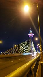 Illuminated bridge against sky at night