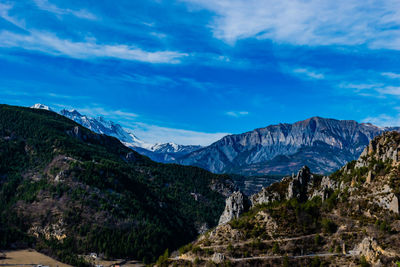 Scenic view of mountains against blue sky