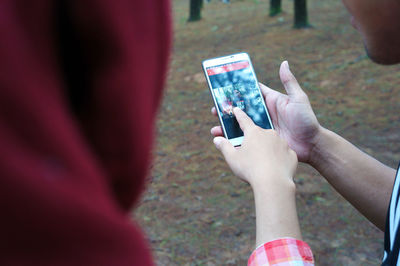 Cropped image of people using smart phone