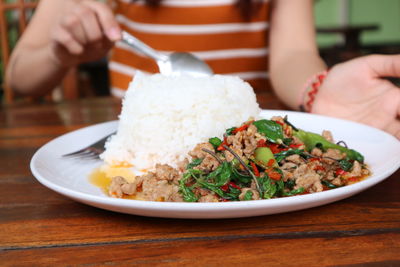 Midsection of woman holding food served in plate