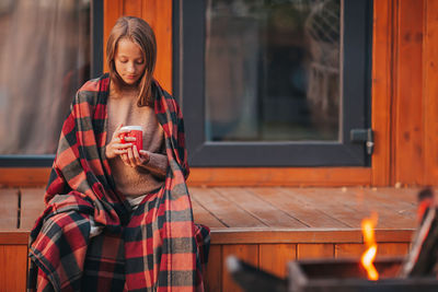 Woman holding coffee cup by window