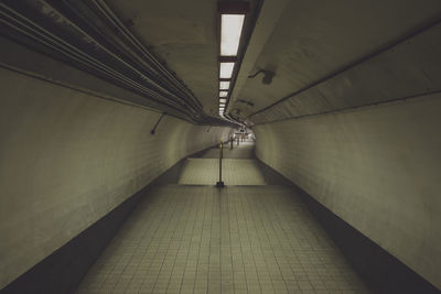 Empty illuminated underground walkway at subway station