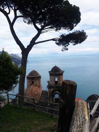 Built structure by trees and building against sky