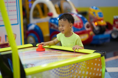 Smiling boy playing air hockey