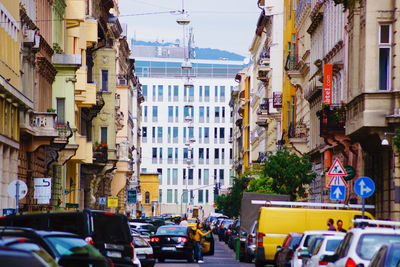 Traffic on road amidst buildings in city