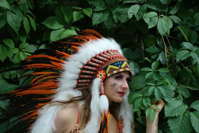 Young woman wearing headdress against plants