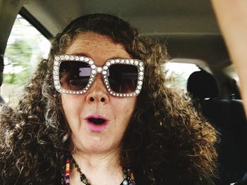Portrait of woman wearing sunglasses in car