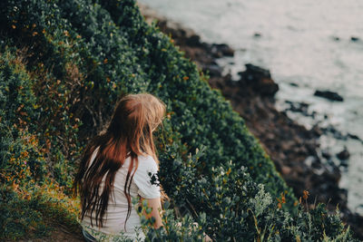 Rear view of woman standing on rock