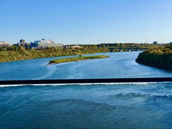 Scenic view of river against clear blue sky