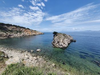 Scenic view of rocks in sea against sky