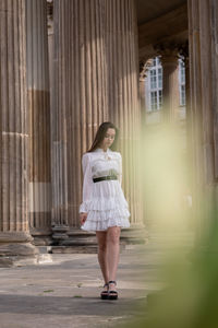 Full length of woman standing against building