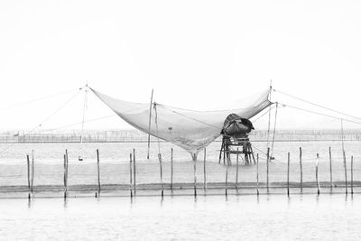 Fishing net on beach against clear sky