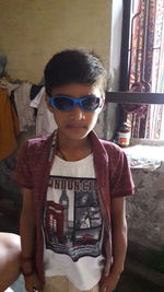 Portrait of boy wearing sunglasses standing at home