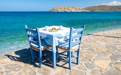 Empty chairs and tables and lounge chair at beach