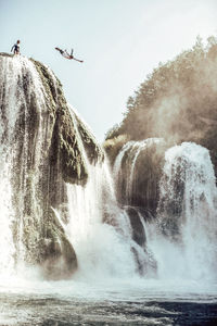 Scenic view of waterfall against sky