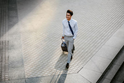 Full length of a man walking with umbrella