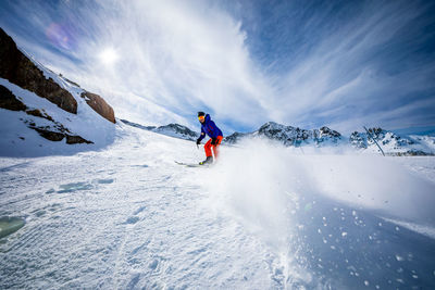 People skiing on snowcapped mountain against sky