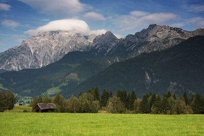 Scenic view of field and mountains against sky