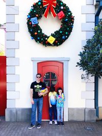 Portrait of family people standing against door