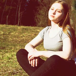 Full length of woman sitting on field