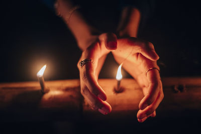 Midsection of woman with burning candle