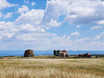 Nuraghe on field against sky