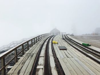 Railroad tracks against sky during winter