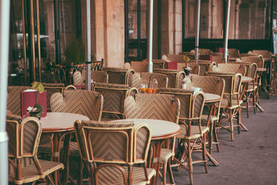 Empty chairs and tables in cafe against building in paris