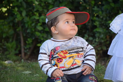 Cute boy looking away while sitting in park