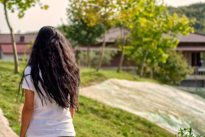 Rear view of woman standing against plants