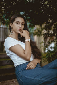 Portrait of beautiful young woman sitting outdoors