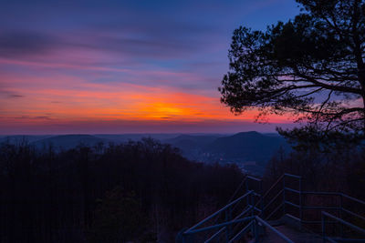 Scenic view of silhouette mountains against orange sky