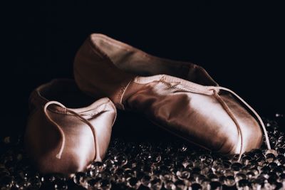 Close-up of ballet shoes against black background