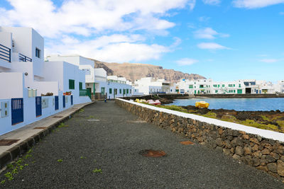 Rocky beach with orzola village and harbor on the background in lanzarote, canary islands, spain