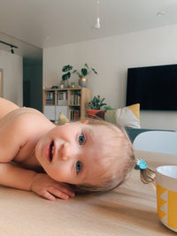 Portrait of cute baby girl sitting at home