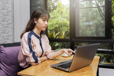 Young woman using laptop at home