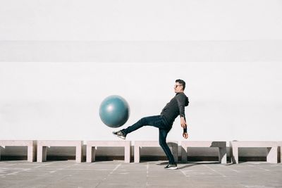 Full length of young man standing against balloons