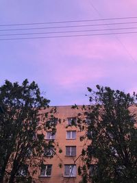 Low angle view of trees and buildings against sky