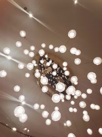 Low angle view of illuminated light bulbs hanging from ceiling