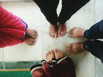 Low section of people standing on tiled floor