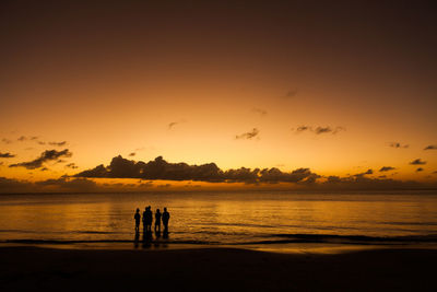 Silhouette people at beach during sunset