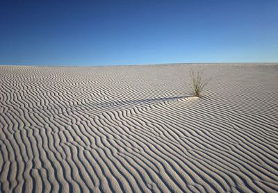 Scenic view of desert against clear blue sky