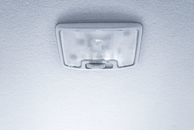 Close-up of electric lamp against white wall