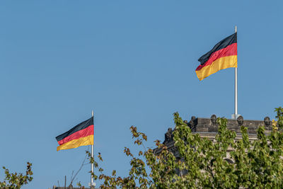 Low angle view of flag flags against clear sky